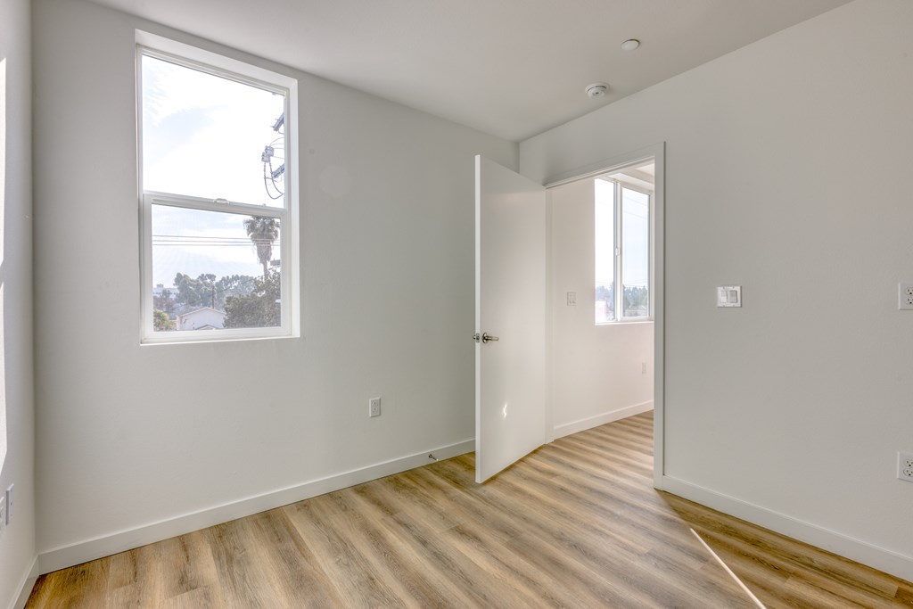 Large room with wooden floors and a large window.
