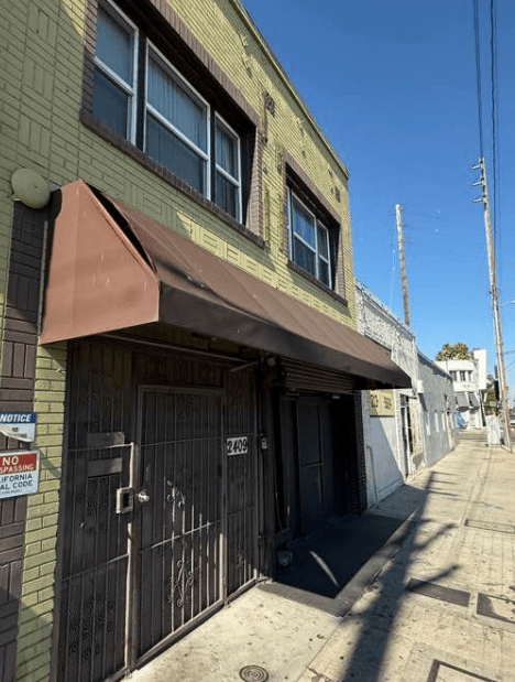 A building with a brown awning and a sign that says "NO PARKING ANY TIME".
