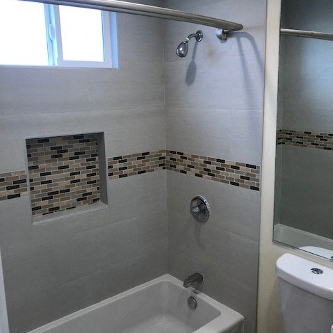 A bathroom with a shower, tub, and toilet.