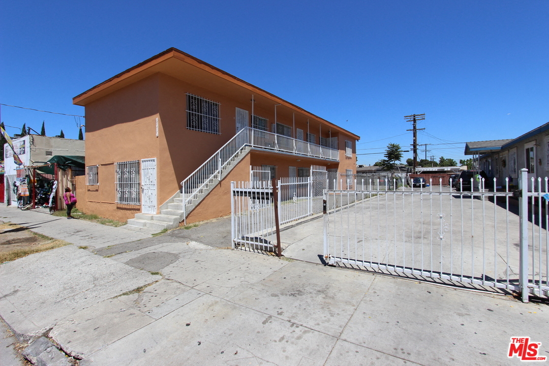 A brown building with a metal fence in front.