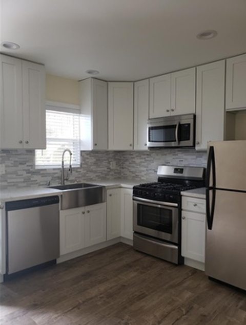 A kitchen with white cabinets and stainless steel appliances.