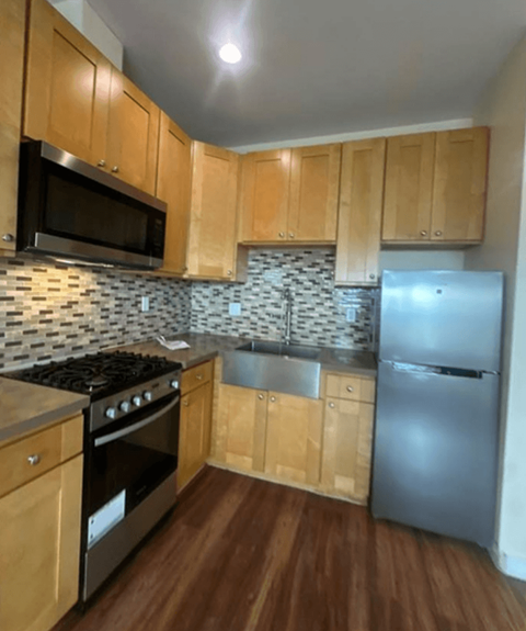 A kitchen with wooden cabinets and a black stove top oven.