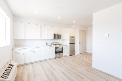 A kitchen with white cabinets and a stainless steel refrigerator.