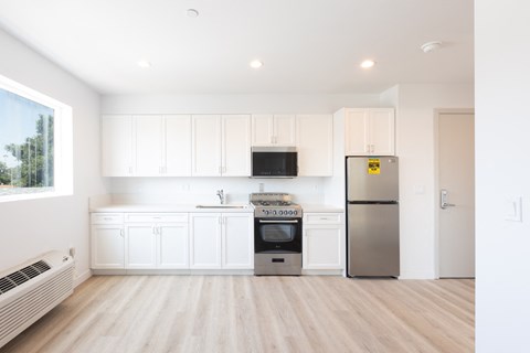 a kitchen with white cabinets and a stainless steel refrigerator