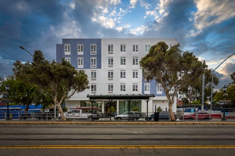 A modern white and blue building with trees in front.