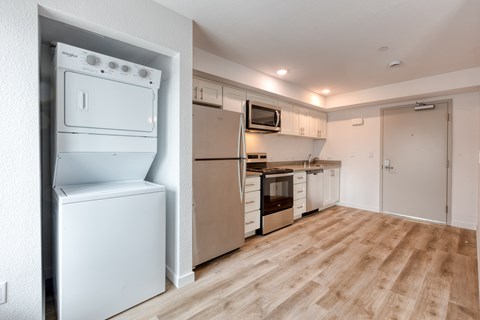 A white fridge and oven in a kitchen with wooden flooring.