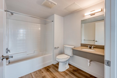 A white bathroom with a toilet, sink, and bathtub.