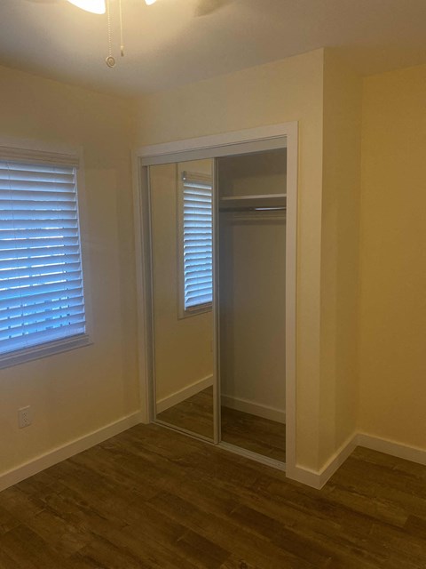 A room with a door and a window with blinds.