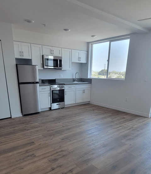 A kitchen with wooden floors and stainless steel appliances.