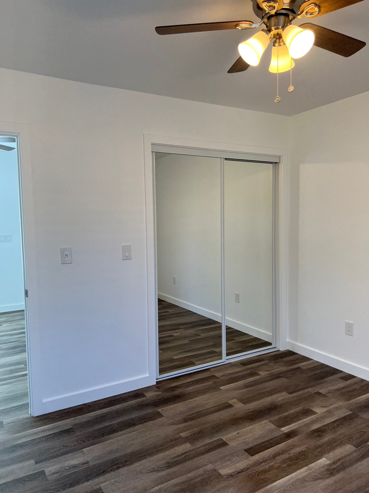 a bedroom with a closet and a ceiling fan