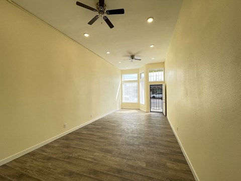 A room with a ceiling fan and wooden flooring.