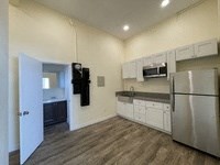 A kitchen with a refrigerator, microwave, and oven.