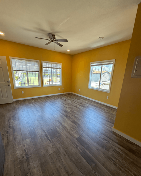 A room with yellow walls and a ceiling fan.