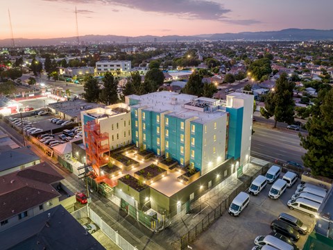 A multi-story building with a parking lot in front of it.