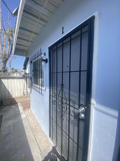 A white wall with a black gate and a number 1 on it.