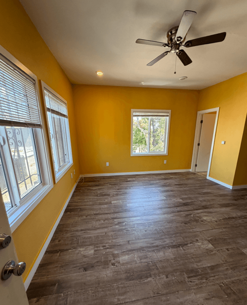 A room with a ceiling fan and a window.