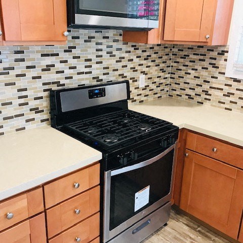 A black stove top oven with a digital display in a kitchen with brown cabinets.