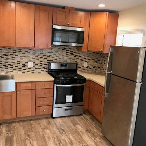 A kitchen with wooden cabinets and a black stove top oven.