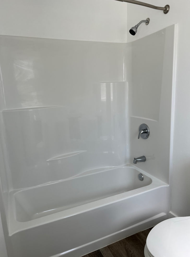 a white bathroom with a tub and a toilet