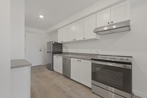 A kitchen with white cabinets and stainless steel appliances.