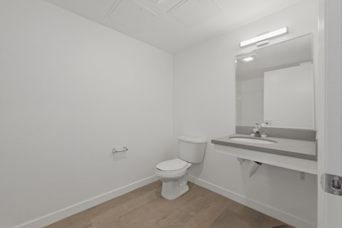 A white toilet sits in a bathroom next to a sink.