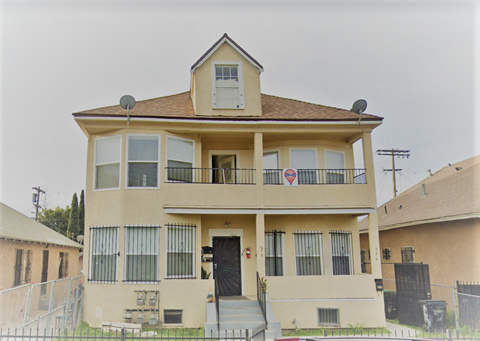 A two-story house with a balcony on the second floor.