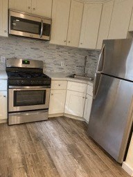 A kitchen with a stainless steel refrigerator, oven, and microwave.