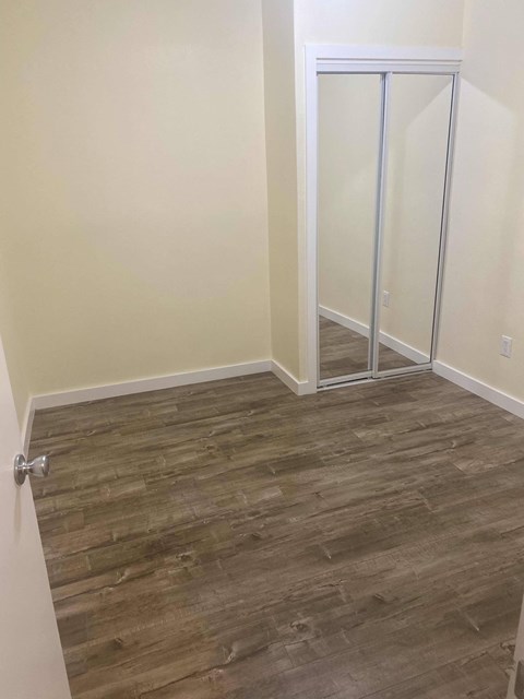 A room with a glass door and wood flooring.