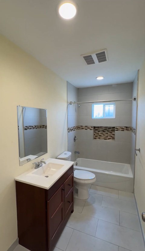 A bathroom with a sink, toilet, and bathtub.