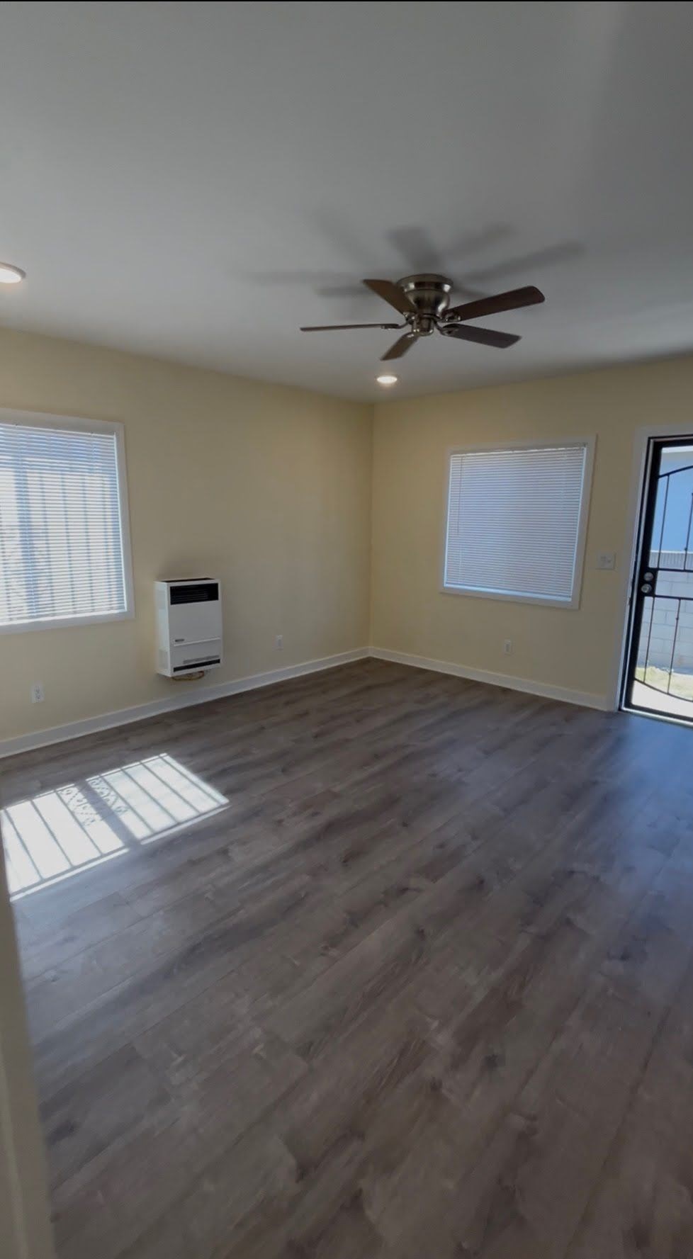 A room with a ceiling fan and a window.