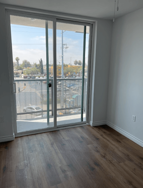 A room with a sliding glass door leading to a parking lot.