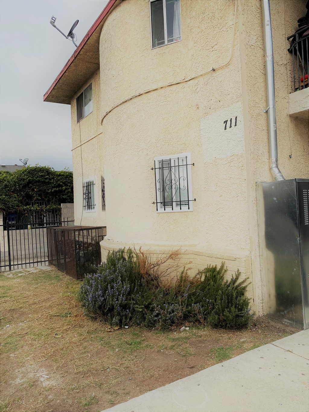 the side of a building with a yard and a fence
