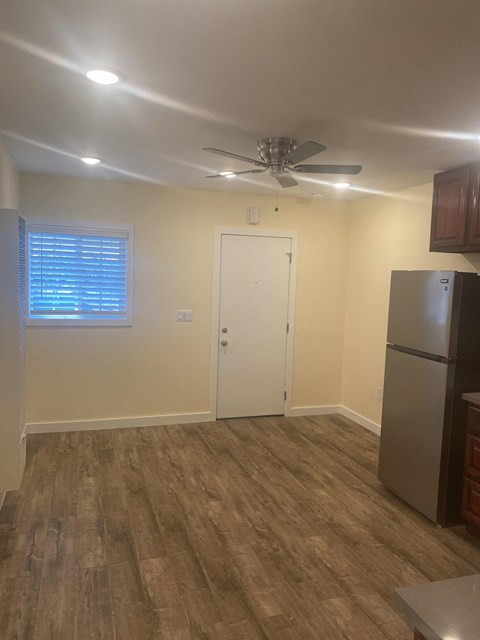 A kitchen with a refrigerator and a ceiling fan.