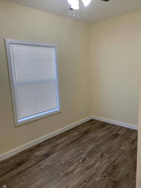 A room with a window and wooden flooring.