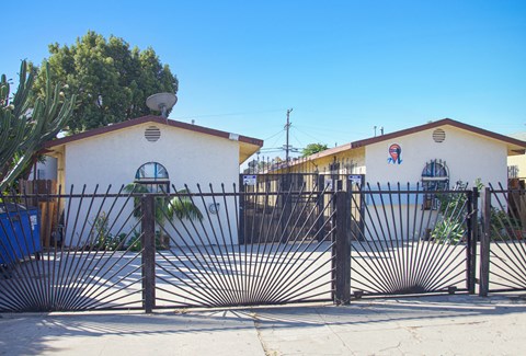 A white building with a black gate in front.