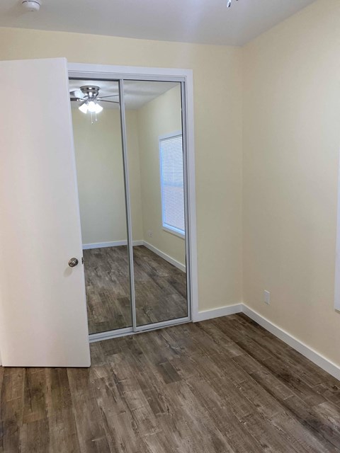 A room with a white door and a mirror on the wall.