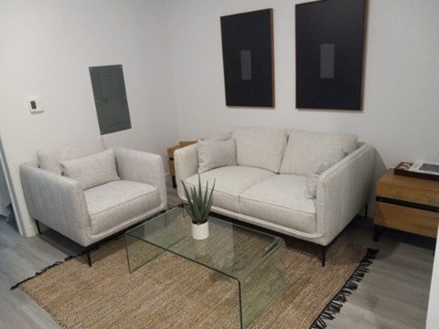 A living room with two couches and a glass coffee table.