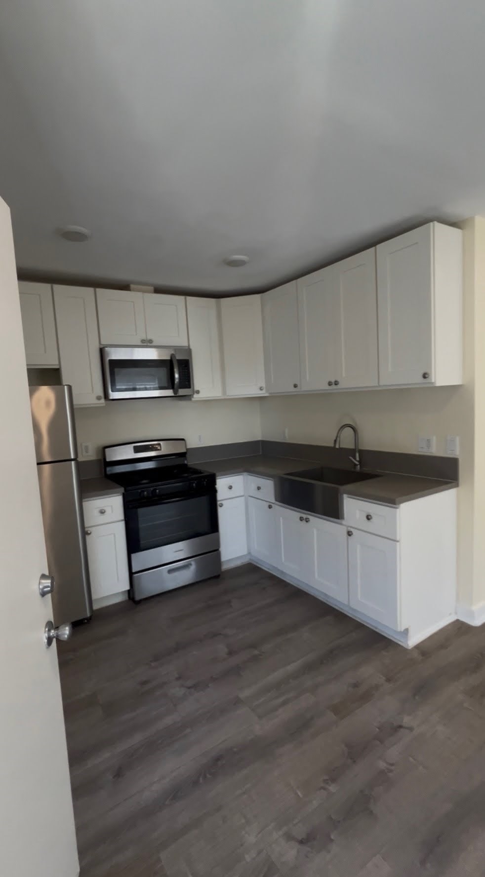 A kitchen with white cabinets and stainless steel appliances.