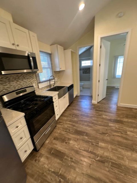 A kitchen with a black stove top oven and white cabinets.
