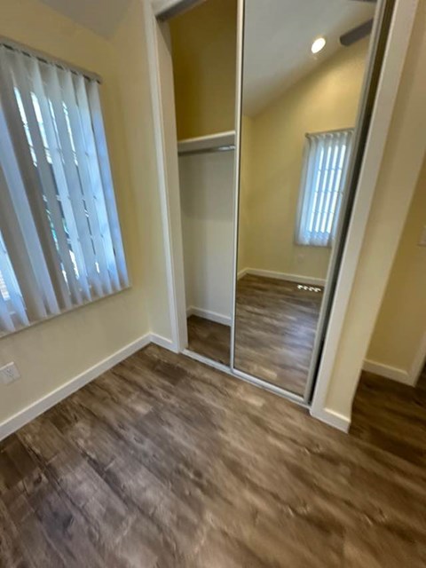 A room with a wooden floor and a large mirror.