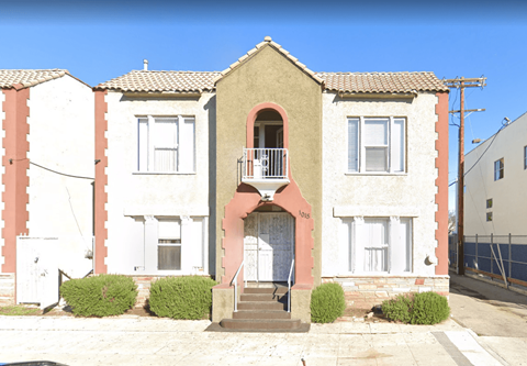 A two-story house with a balcony on the second floor.