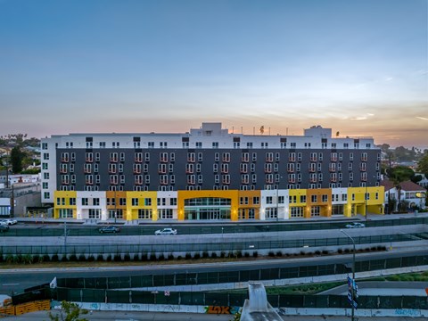 A modern building with a mix of grey, white, and yellow sections.