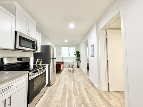 A modern kitchen with white cabinets and stainless steel appliances.