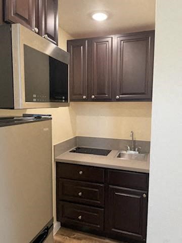 A kitchen with brown cabinets and a white refrigerator.