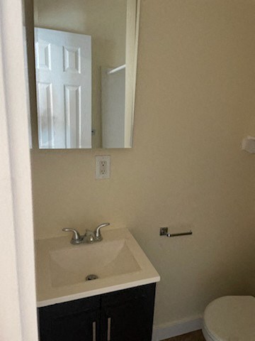 A bathroom with a sink, mirror, and toilet.