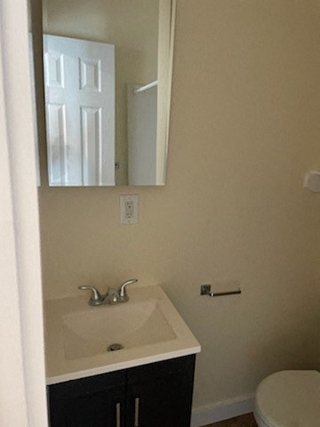 A bathroom with a sink, mirror, and toilet.
