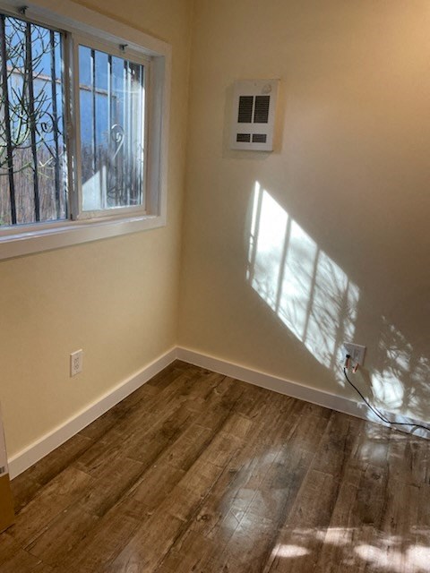 A room with a window and a wall-mounted air conditioning unit.
