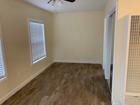 a living room with wood floors and a ceiling fan