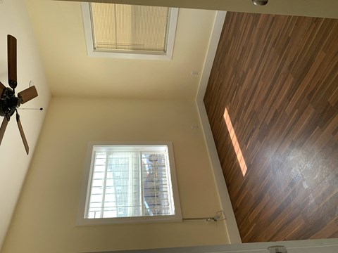 a view of a window with a wooden floor and a ceiling fan