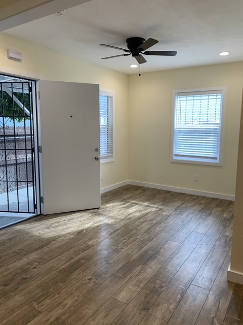 A room with a ceiling fan and a white door.